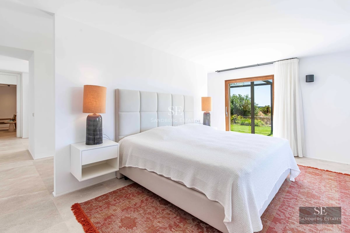 Spacious living room with sea views through panoramic windows. Modern design, light wood floors, neutral sofas, and minimalist decor. Natural lighting.