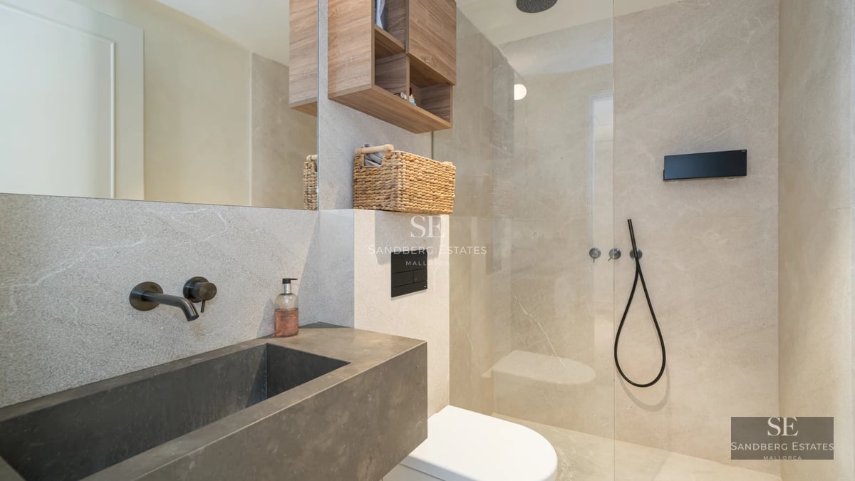 Aerial view of a modern villa with an infinity pool, surrounded by lush greenery and featuring spacious terraces.