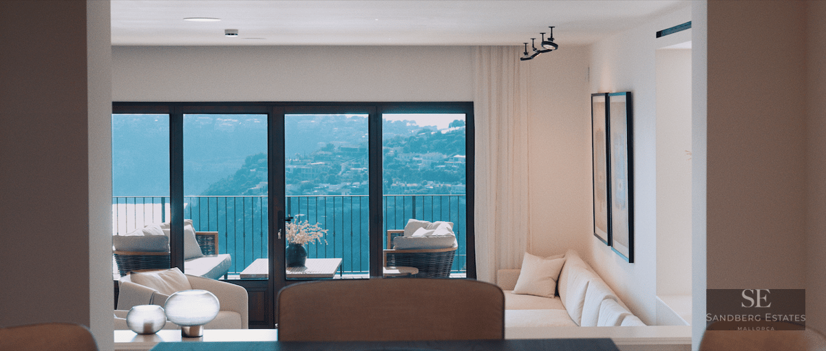 Bright living room with white sofa and large windows overlooking a scenic hillside and balcony furniture.