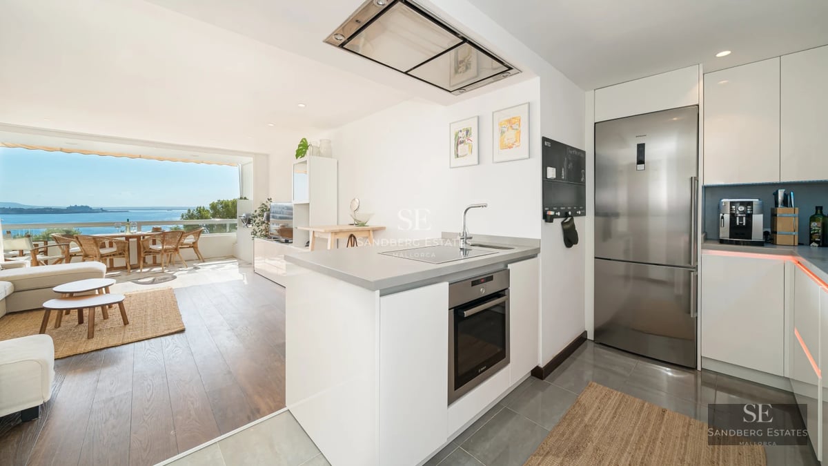 Spacious living room with floor-to-ceiling windows, natural light, modern design furniture and access to a terrace with stunning views. Light wood floors and minimalist details.