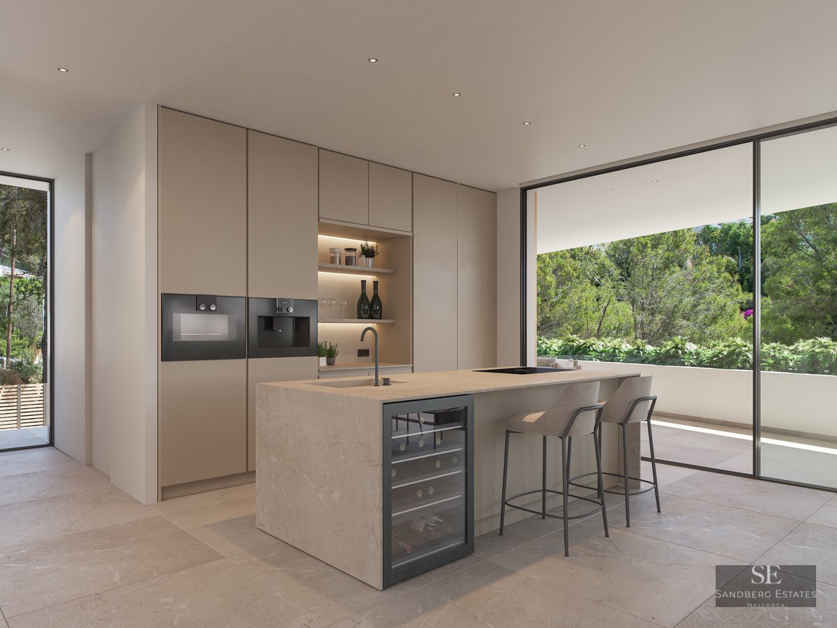 Modern minimalist kitchen with a stone island, wine cooler, and large sliding glass doors opening to a lush terrace.