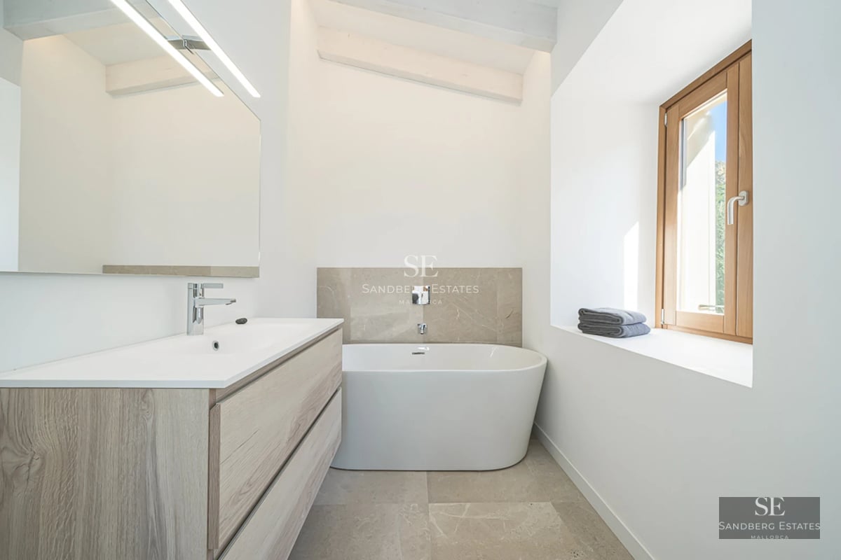 Spacious, bright living room with large windows, modern sofas, designer rug, and panoramic sea views.