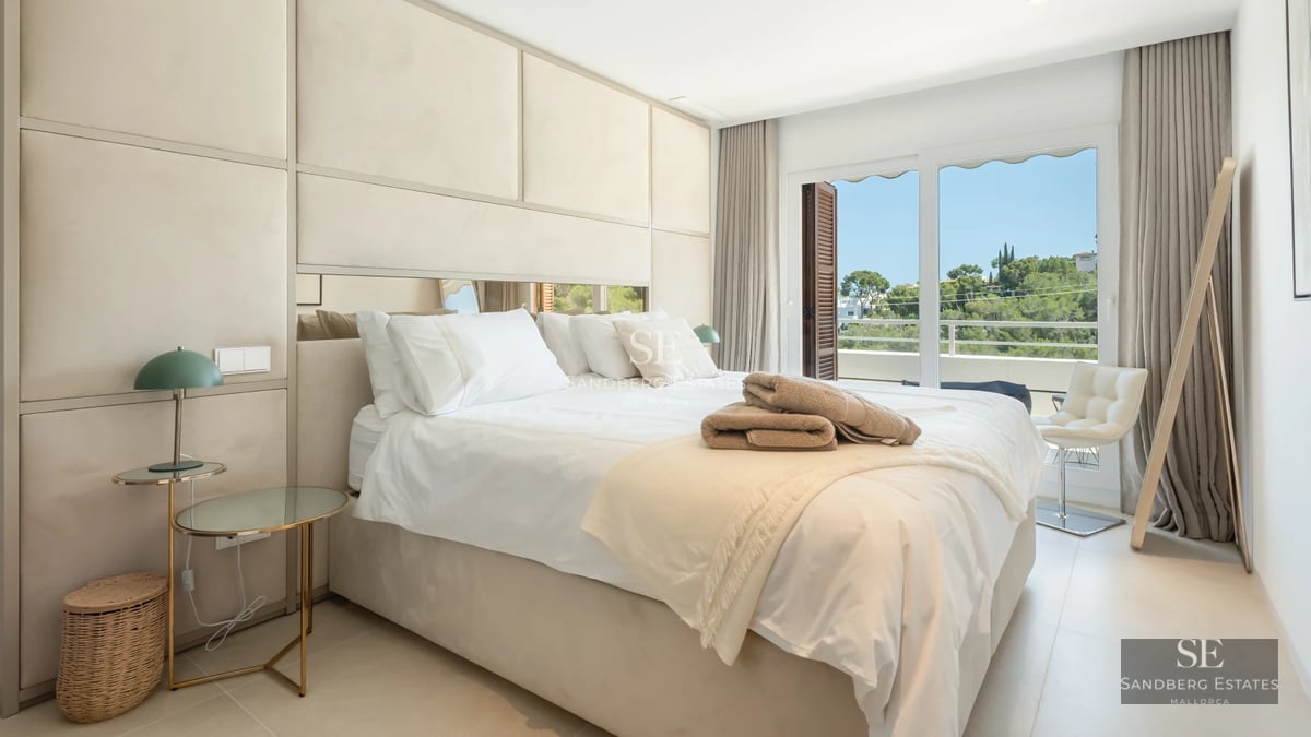 Aerial view of a luxurious villa with infinity pool, landscaped garden, and minimalist modern architecture. Clear blue sky.