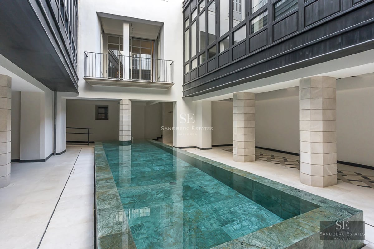 Spacious balcony with sea view, modern furniture, glass railing, wooden floor. Minimalist and elegant design.