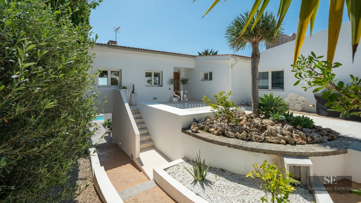 Exterior view of modern villa featuring an infinity pool, spacious terraces, and lush gardens. Minimalist and elegant architectural design.