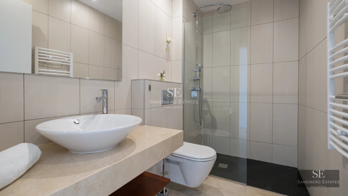 View of a modern villa with infinity pool. Minimalist architecture with large windows and terrace with sun loungers.