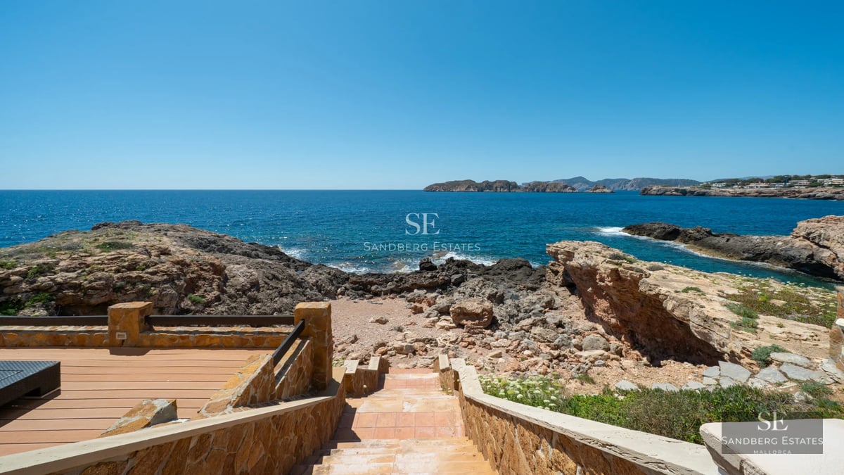 Spacious sea-view balcony, glass railing, modern furniture, wooden floor. Minimalist design with natural lighting.