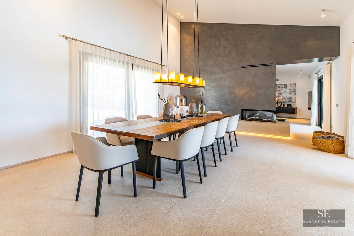 View of a modern villa with reflective pool. Minimalist design, large windows, lush natural surroundings and clear sky.