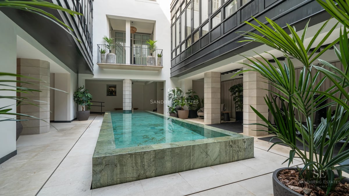 Exterior view of a modern villa featuring an infinity pool and expansive terraces overlooking the sea. Minimalist design and lush gardens.