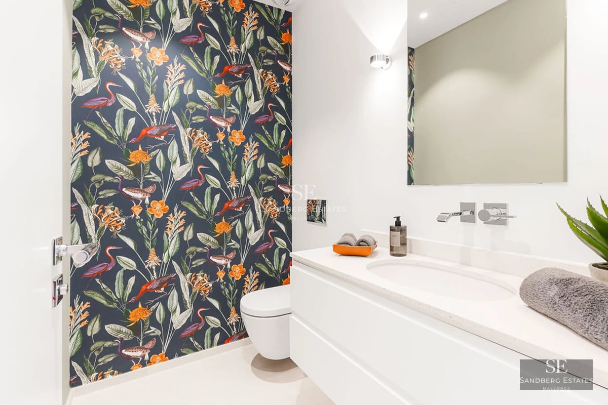 View of infinity pool with modern home. Large windows, elegant design and lush natural surroundings. Ideal for relaxation and luxury.