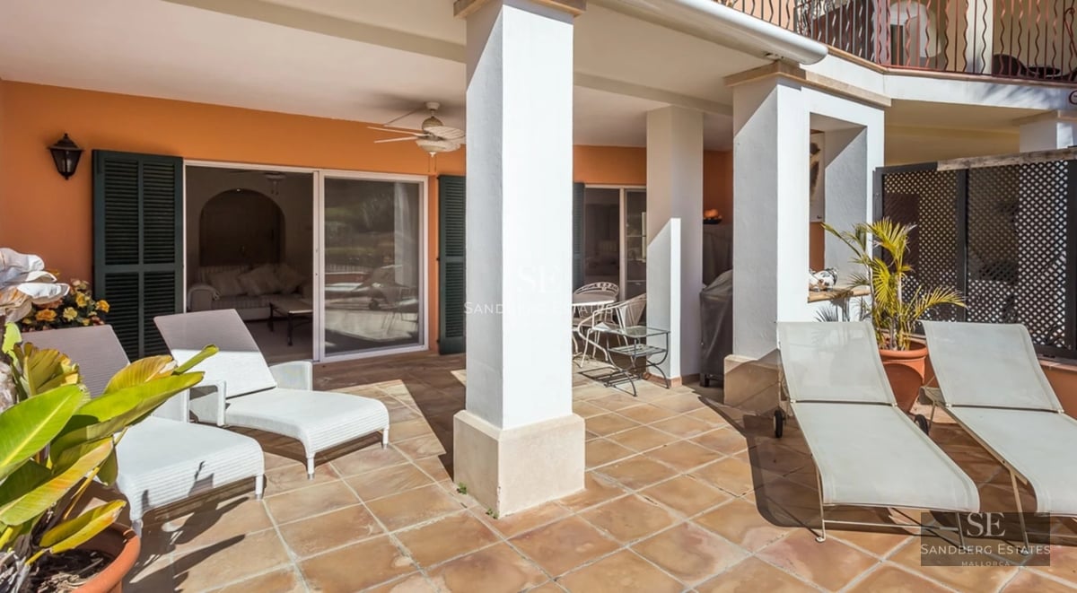 Exterior view of modern villa with swimming pool, minimalist architecture, large windows, manicured garden and clear sky.