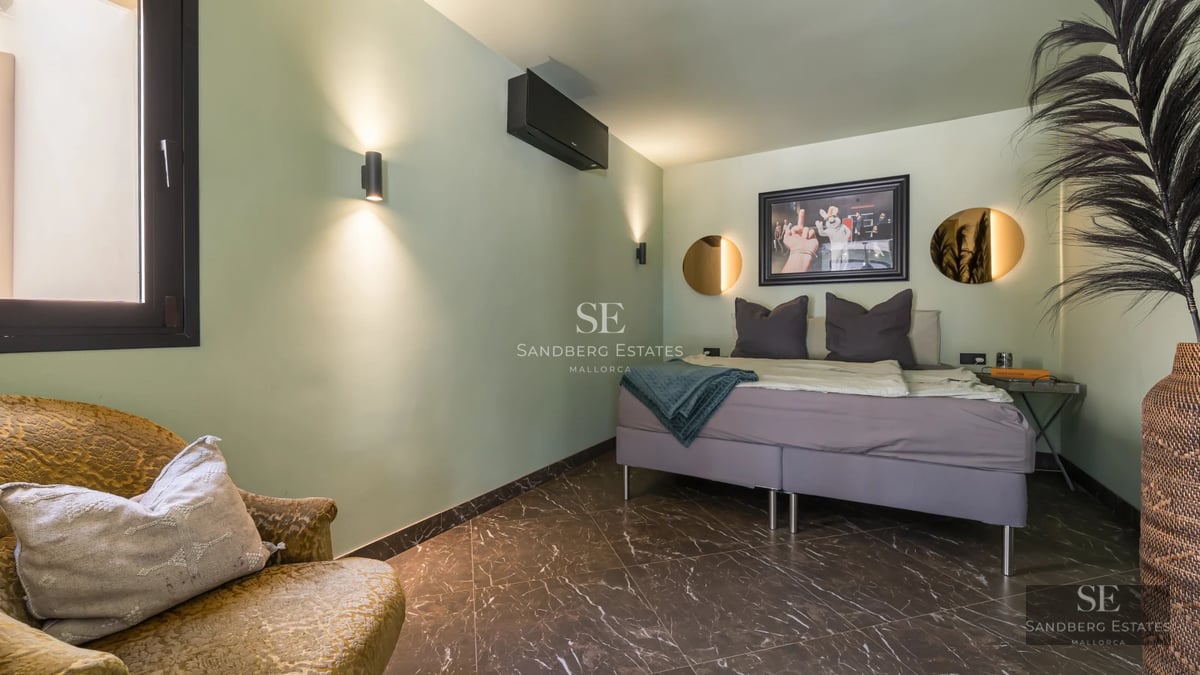 Exterior view of a luxurious villa with reflecting pool and lush greenery. Modern architecture with large windows.