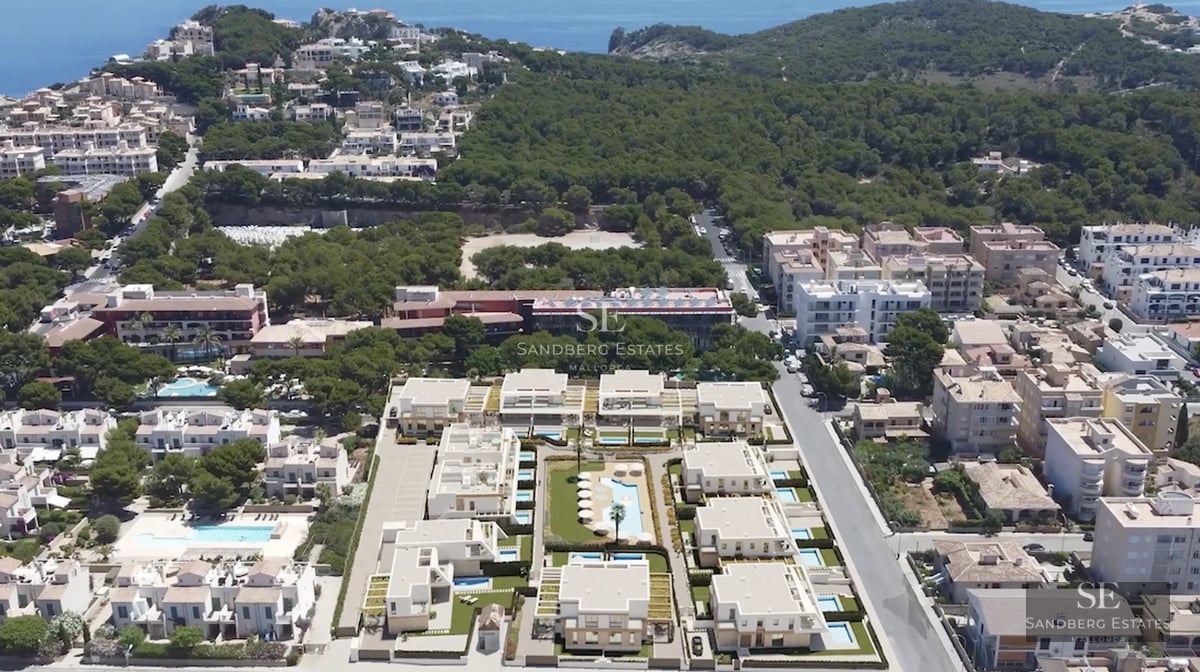 View of a modern villa featuring an infinity pool, expansive glass windows, and minimalist garden. Clean and elegant architectural design.
