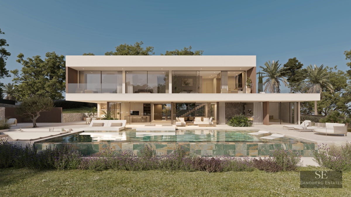 Two-story modern white villa with large windows and an infinity pool reflecting the building under a clear blue sky.