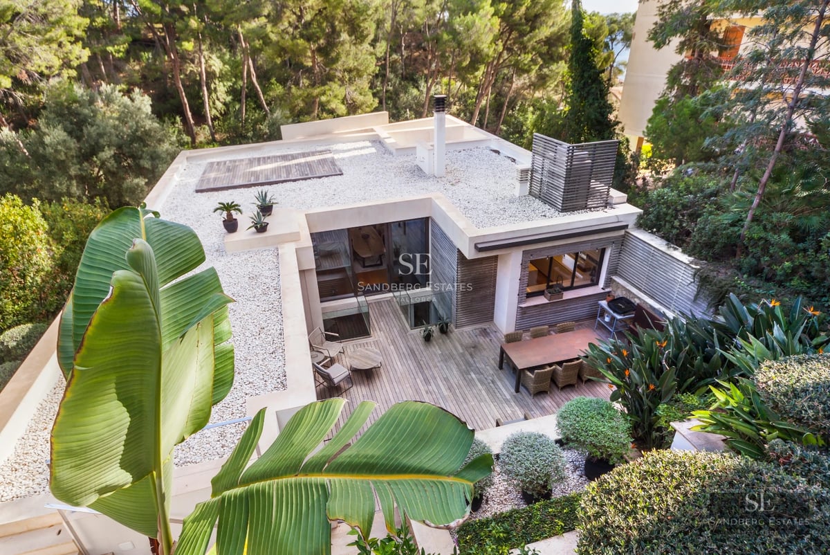 Modern facade with reflecting pool. Minimalist architecture, large windows, warm lighting, and impeccable landscaping.