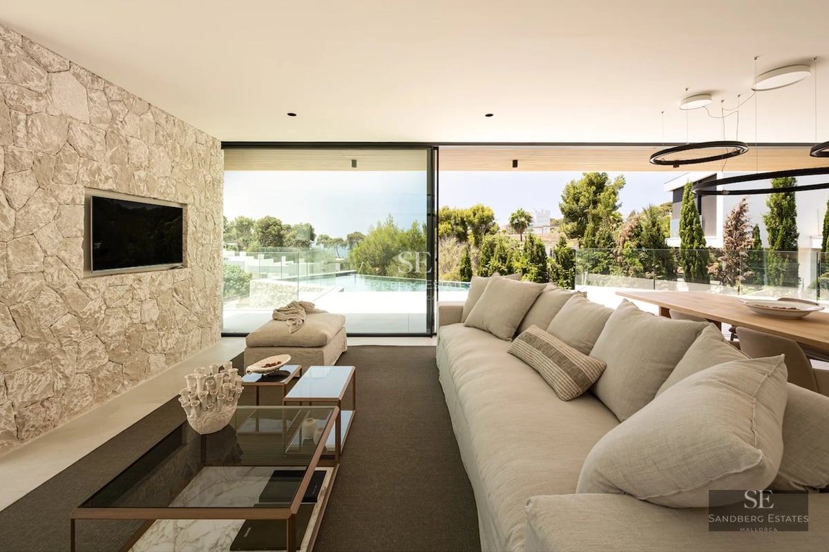 Exterior view of a modern house with an infinity pool. Features include minimalist architecture, large windows, and a lush garden.