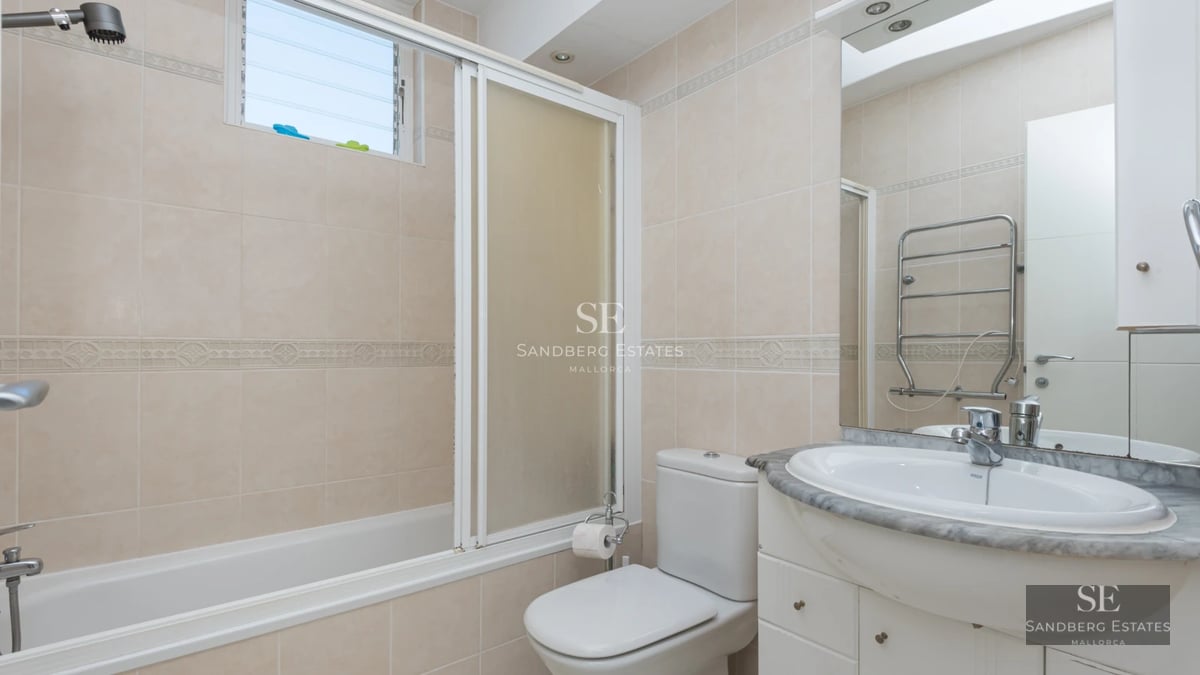 Modern penthouse with glass-enclosed balcony, stunning views, stylish furniture, and abundant natural light.