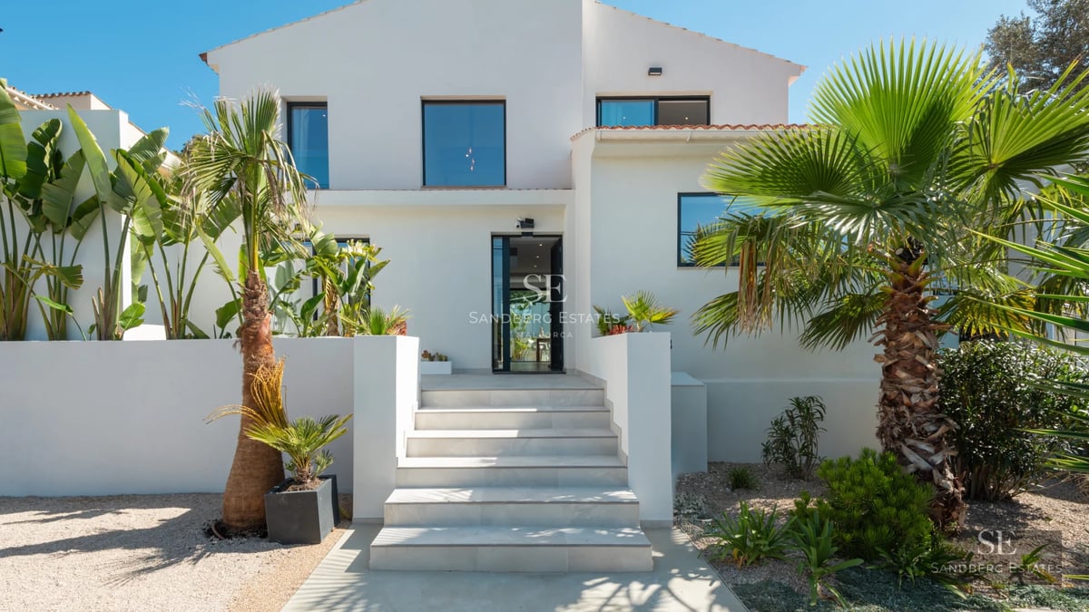 Exterior of modern villa with infinity pool, lounge chairs, garden, and panoramic views. Minimalist architecture with large windows.