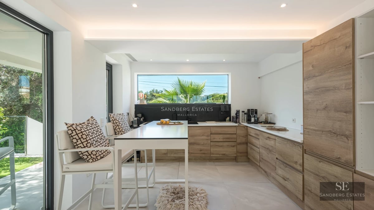 Panoramic view of a modern villa featuring an infinity pool, lush garden, and contemporary architecture. Bright and spacious.