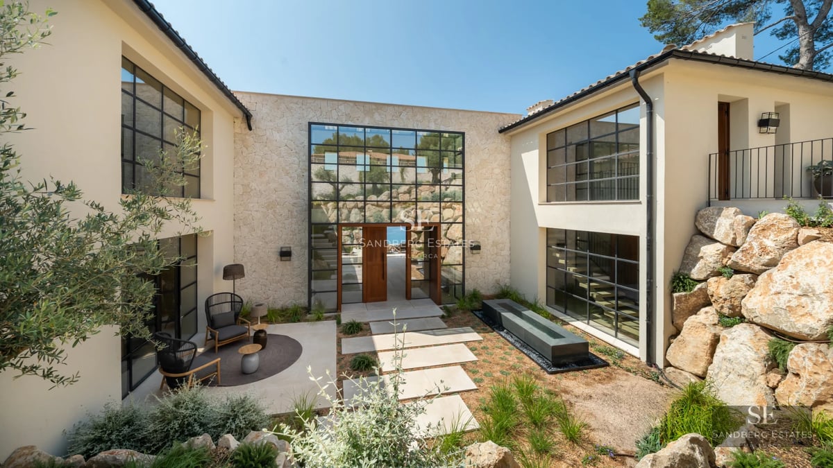 Exterior view of a modern villa with reflecting pool. Minimalist architecture, large windows and lush vegetation.