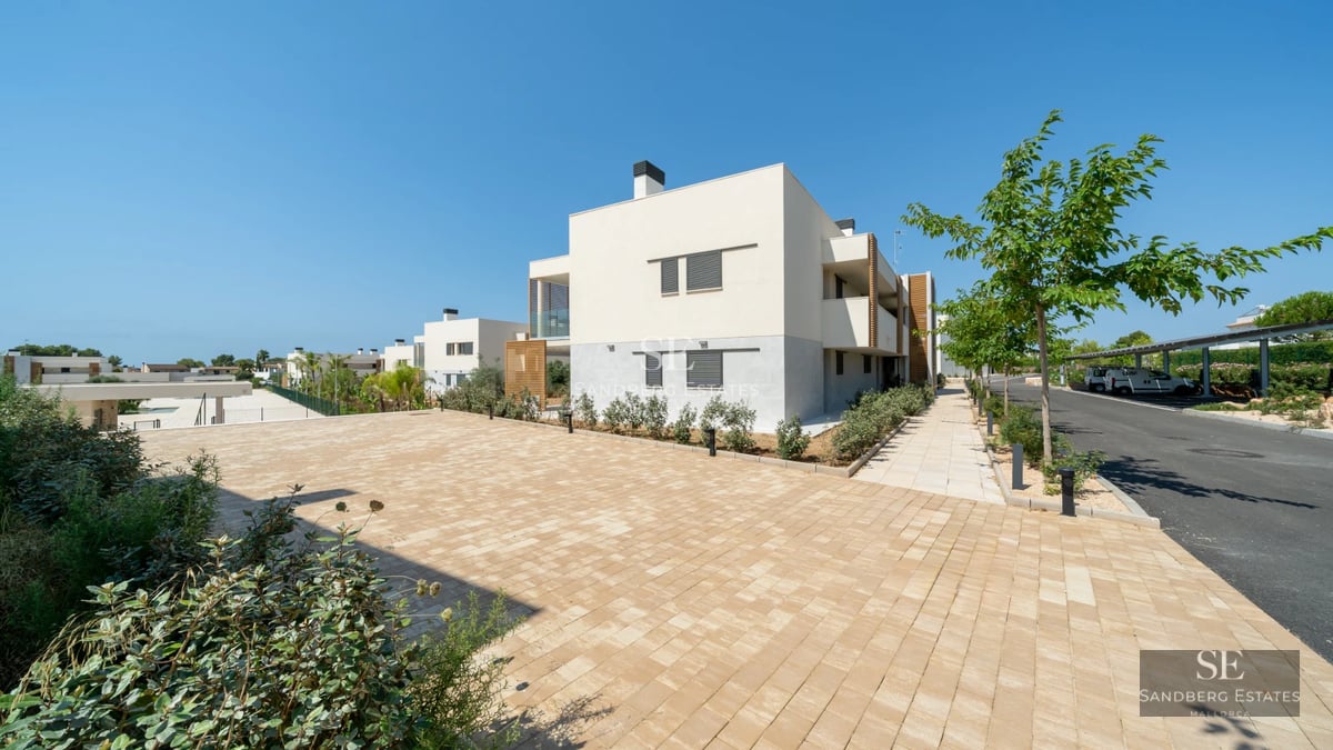 Spacious terrace featuring modern furniture, wood flooring, and breathtaking views. Glass railing. Soft lighting and decorative plants.