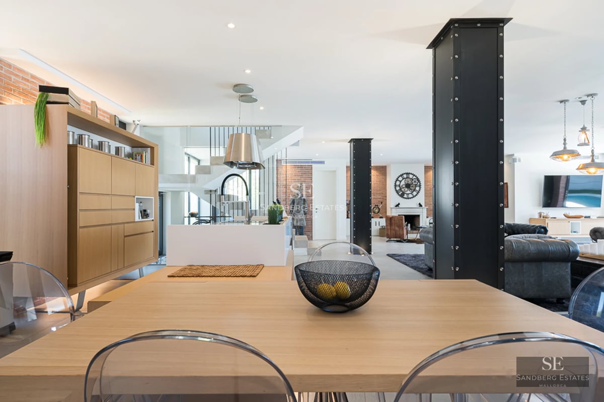 Exterior view of a modern villa with infinity pool, sun loungers, and expansive windows offering panoramic sea views.