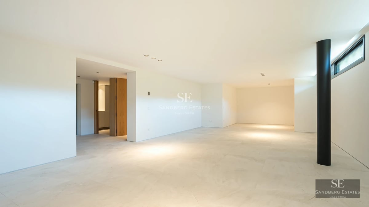 Spacious balcony with sea view. Modern glass railing. Elegant outdoor furniture. Lush vegetation.