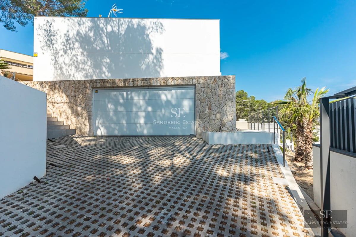 Exterior view of a modern villa with reflecting pool, large windows and elegant landscaping. Contemporary architecture and high-end materials.