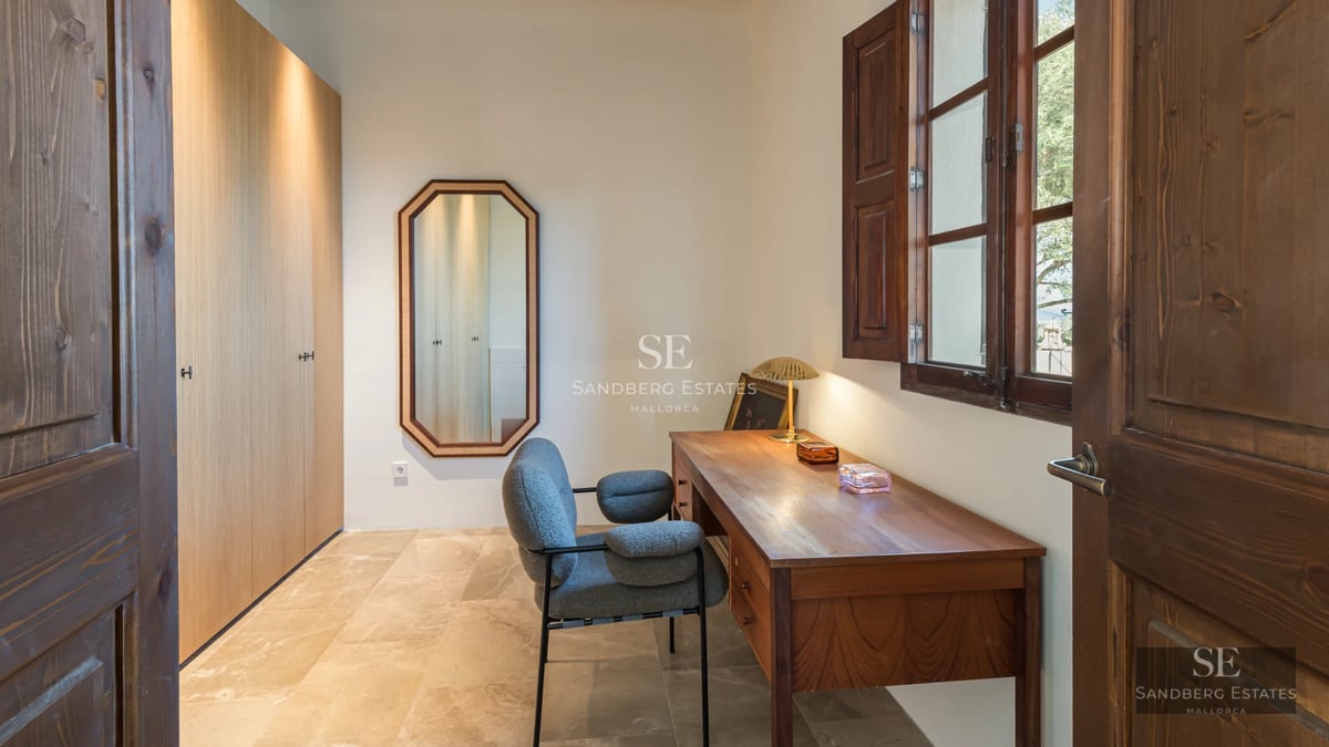 Pool view with wooden deck and armchairs. Modern architecture, natural lighting, lush vegetation and blue sky.