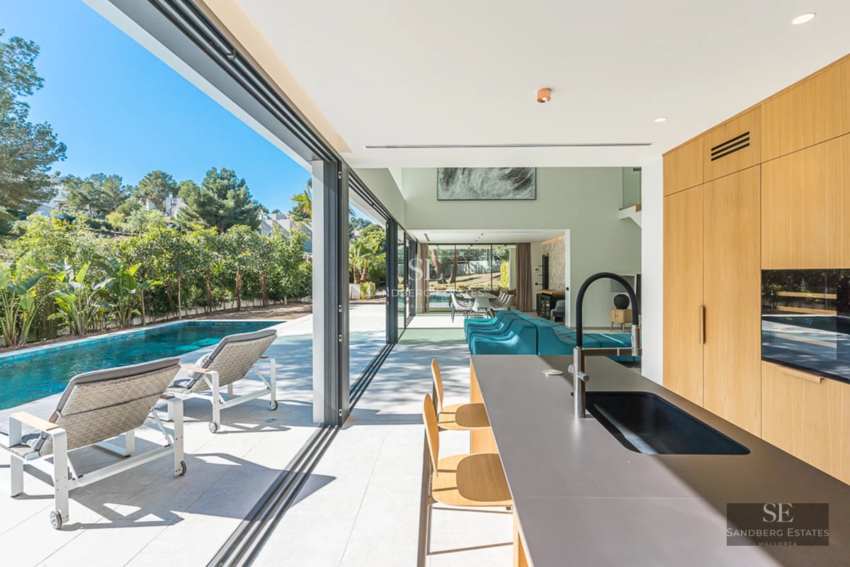 Vue d'une villa moderne avec piscine à débordement, transats et jardin paysager. Design minimaliste avec de grandes baies vitrées et une lumière naturelle abondante.