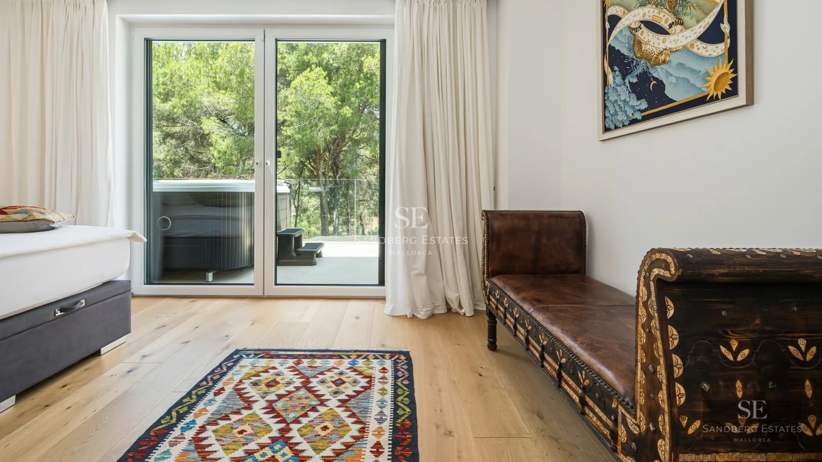View of infinity pool surrounded by lush greenery. Modern architecture, warm lighting and high-end materials.