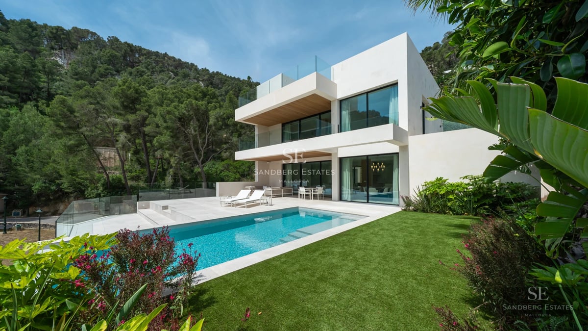 Modern facade with reflective pool. Minimalist architecture, large windows, lush greenery, and clean lines.