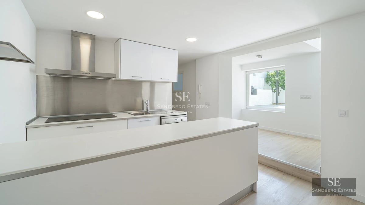 Spacious living room with floor-to-ceiling windows, sea view, modern furniture, and neutral color palette. Abundant natural light.