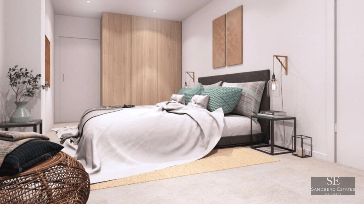 Bright bedroom featuring a large bed, built-in wooden wardrobe, teal pillows, and designer bedside lighting.