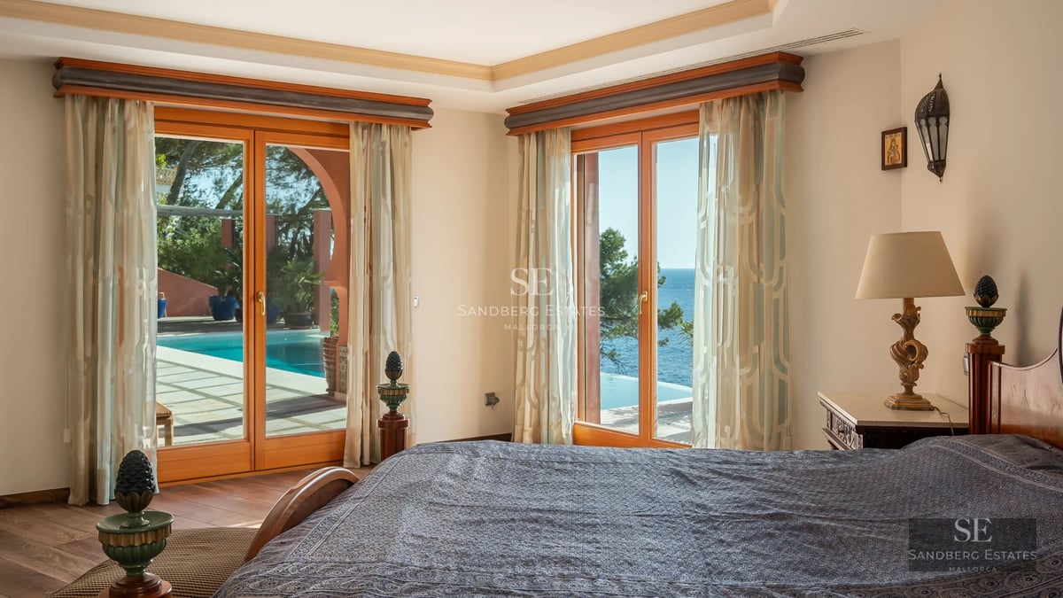 View of a modern pool with ambient lighting, surrounded by a lush garden and minimalist architecture.