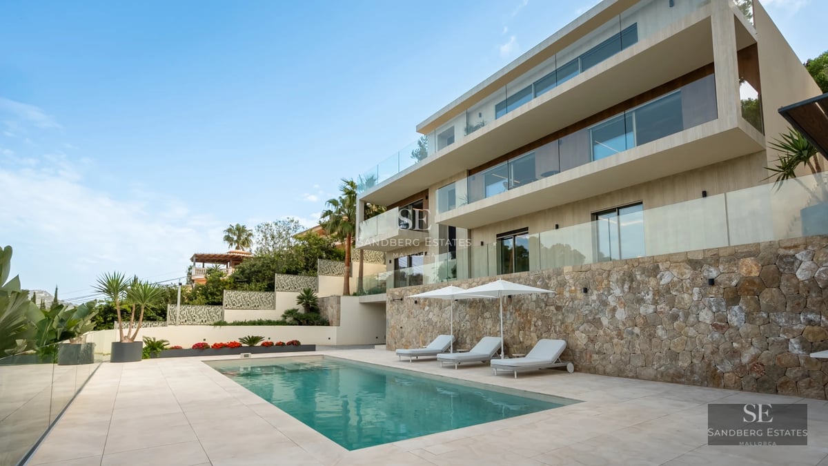 Exterior view of a modern house with a pool, manicured gardens, and large windows reflecting natural light. Minimalist and elegant design.