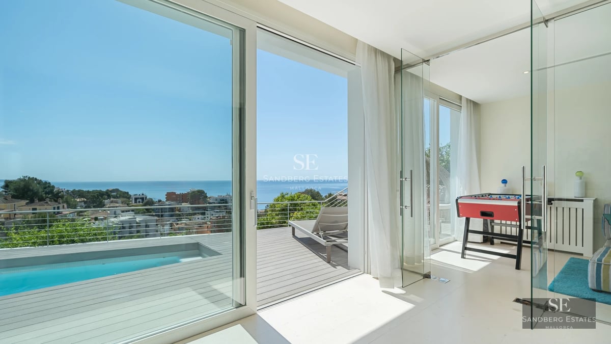 Spacious balcony with panoramic sea views. Modern design with glass railing and elegant outdoor furniture.