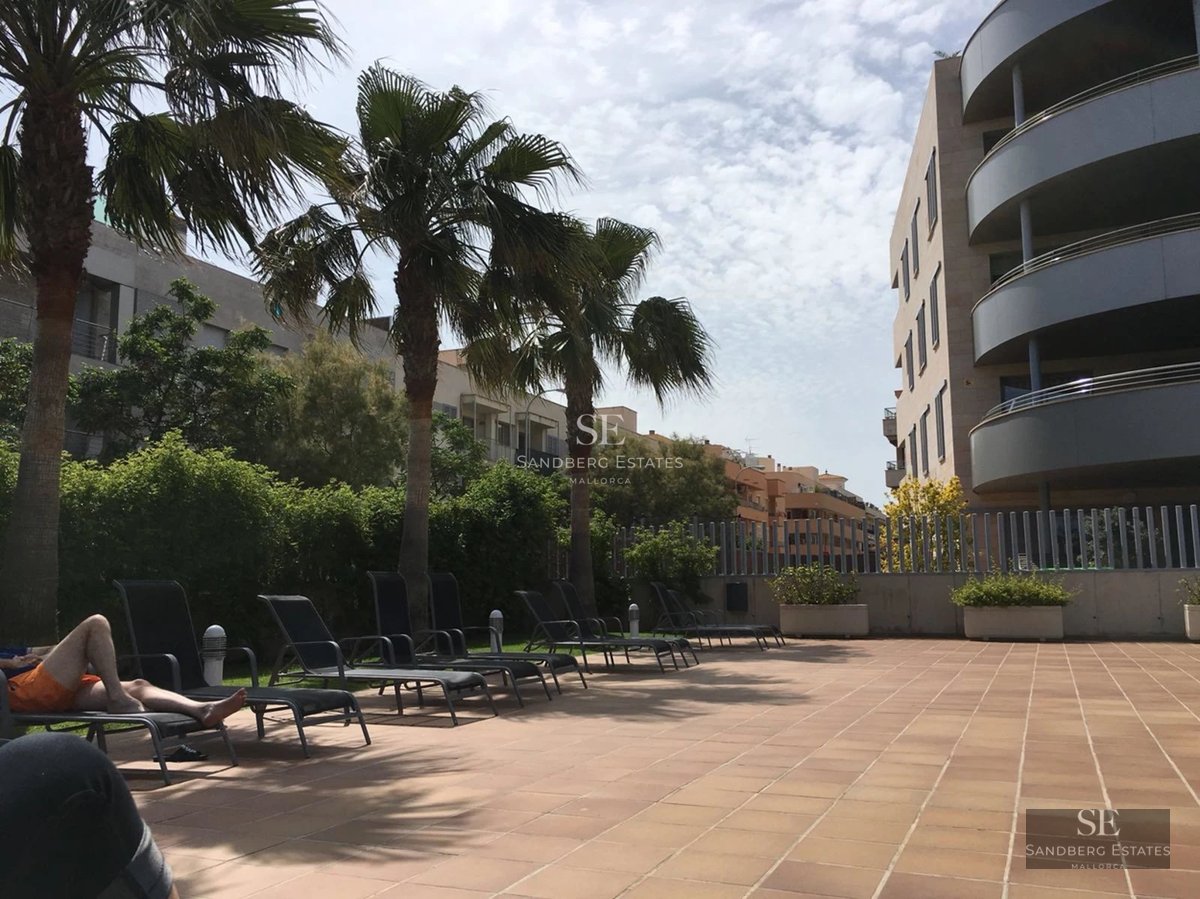 Salon lumineux avec de grandes baies vitrées, canapé beige, parquet clair et vue panoramique sur la mer. Design moderne et élégant.