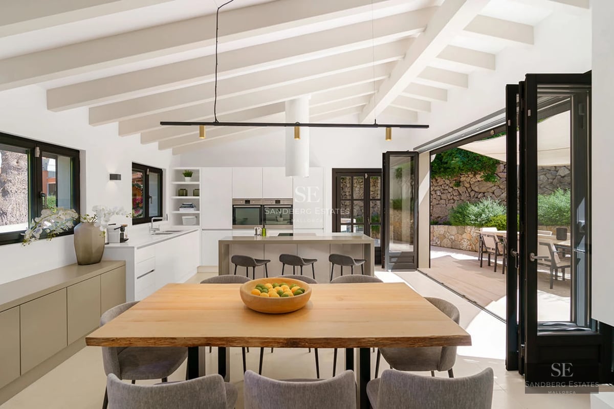View of infinity pool with glass edge and luxurious modern villa in the background featuring large windows and minimalist design.