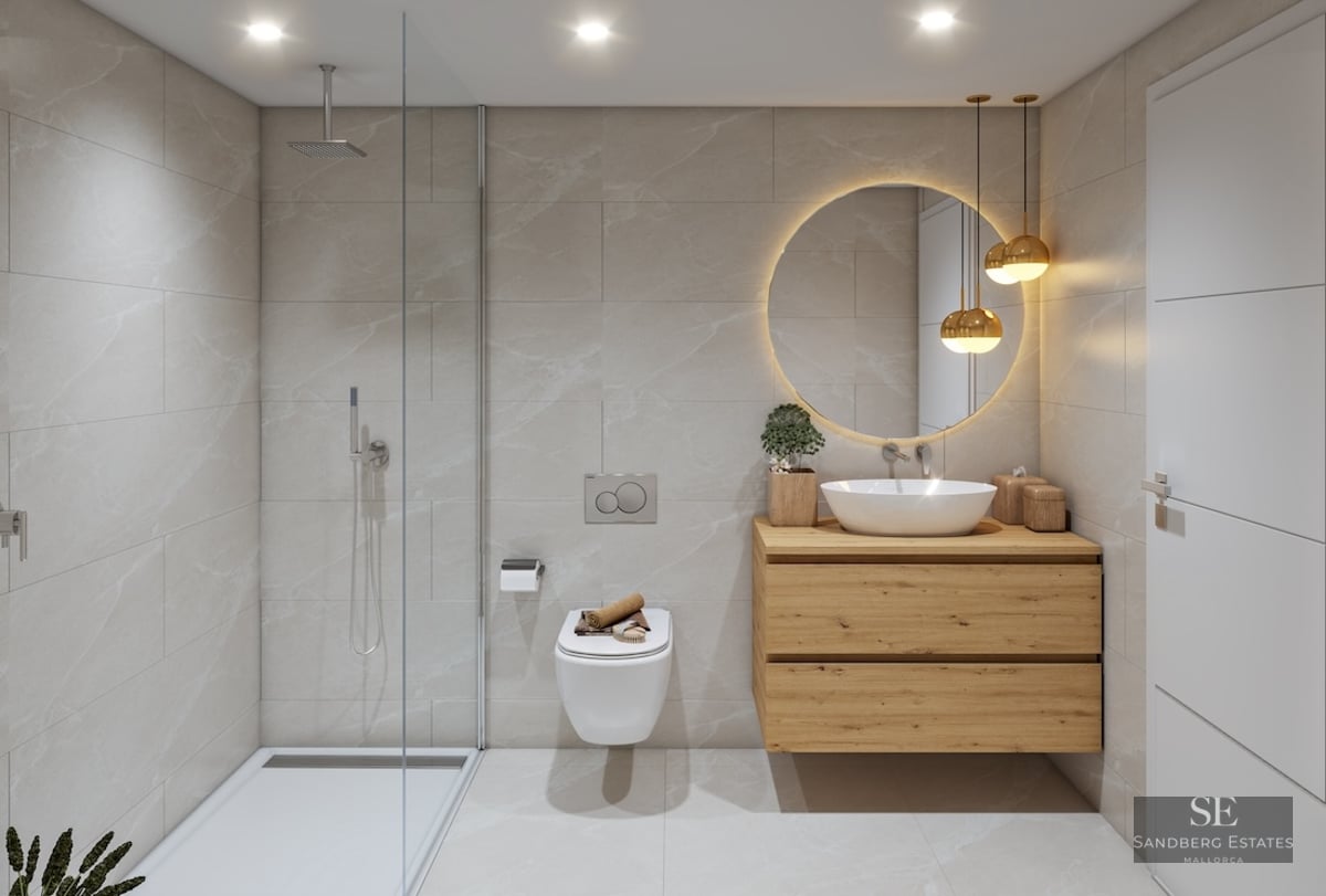 Modern bathroom featuring a glass shower, wooden vanity, backlit circular mirror, and beige marble-effect tiles.