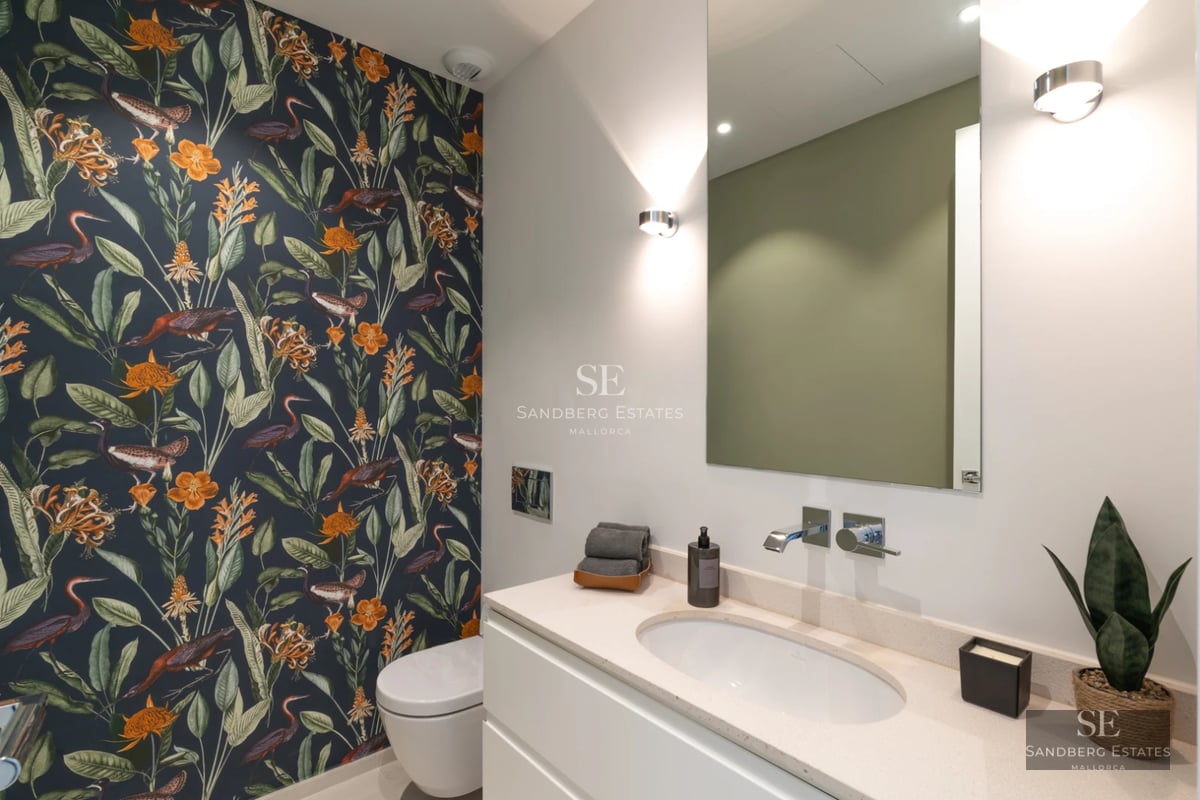 Infinity pool view with lawn, sun loungers and panoramic views. Sleek modern architecture with large windows.