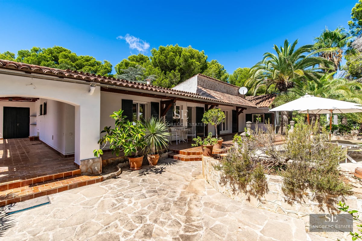 Modern exterior with infinity pool, minimalist garden, white facade and large windows. Warm ambient lighting.