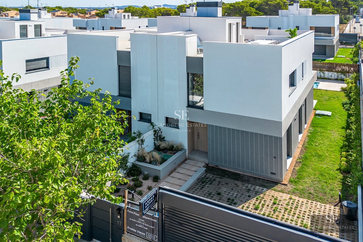 Spacious balcony with panoramic sea views from a modern apartment. Glass railing, minimalist furniture, and abundant natural light.