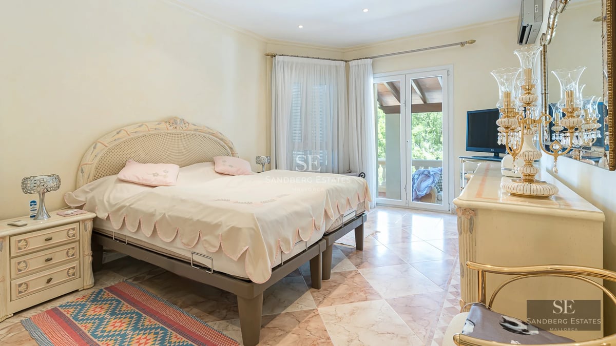 View of a luxurious villa with infinity pool, large windows, wooden terrace, and modern design. Lush garden and sea views.