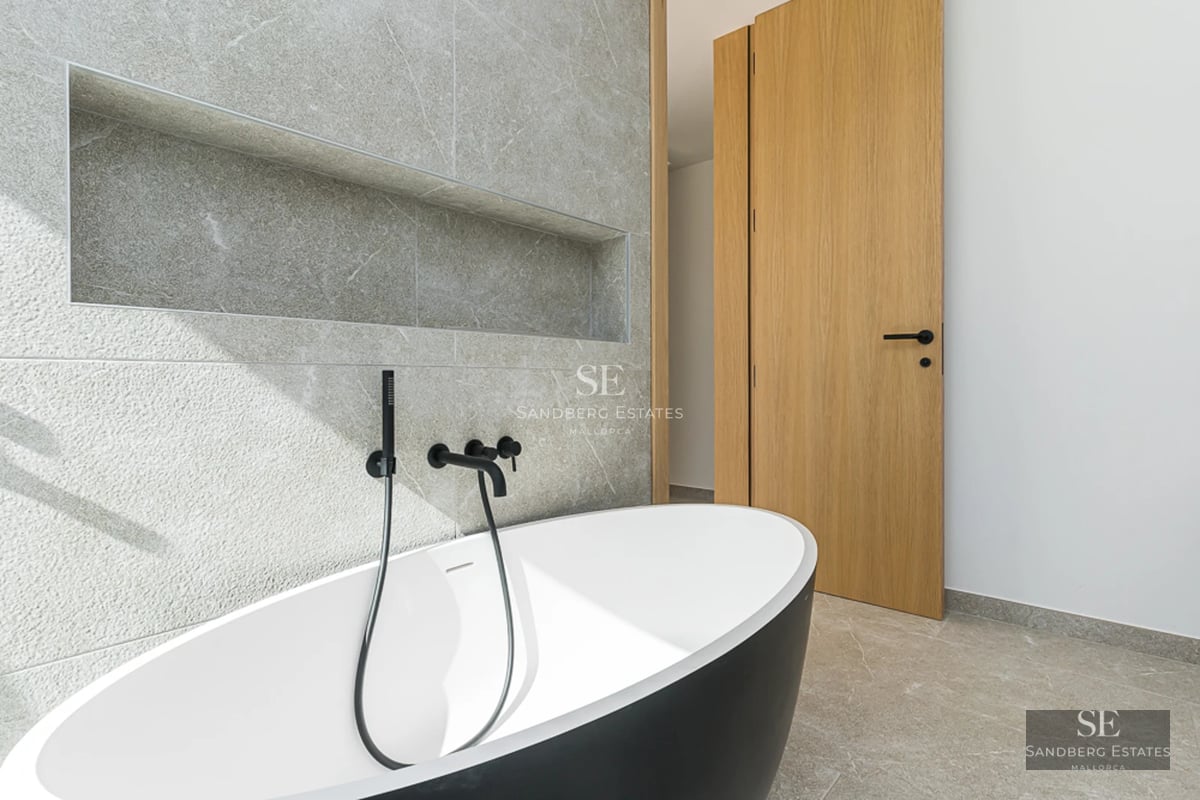 Vaste terrasse avec piscine à débordement et vue panoramique sur la mer. Design moderne avec plancher en bois et mobilier élégant.