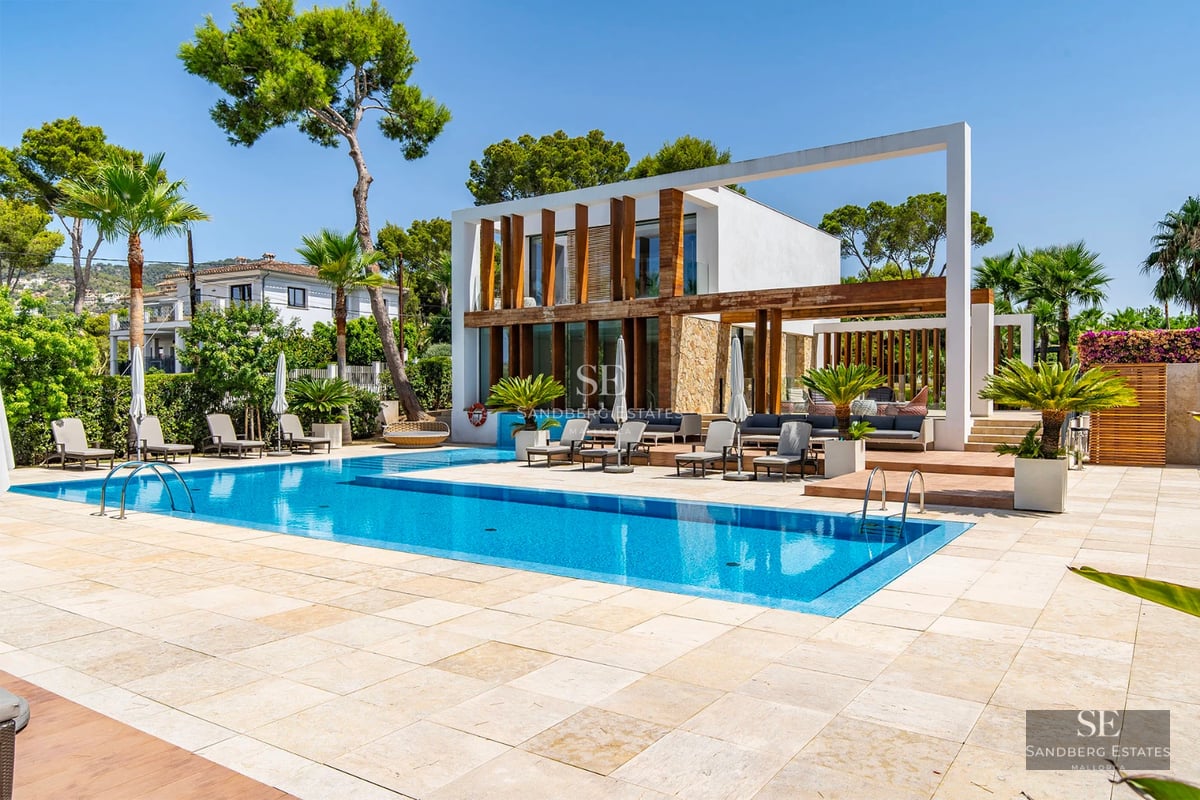 Image of a luxury villa with pool, lush gardens, and modern architecture. Natural lighting highlighting interior and exterior details.