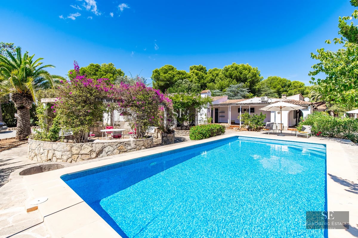 Spacious, bright living room featuring large windows, light wood floors, a modern fireplace, and panoramic sea views. Minimalist and elegant design.