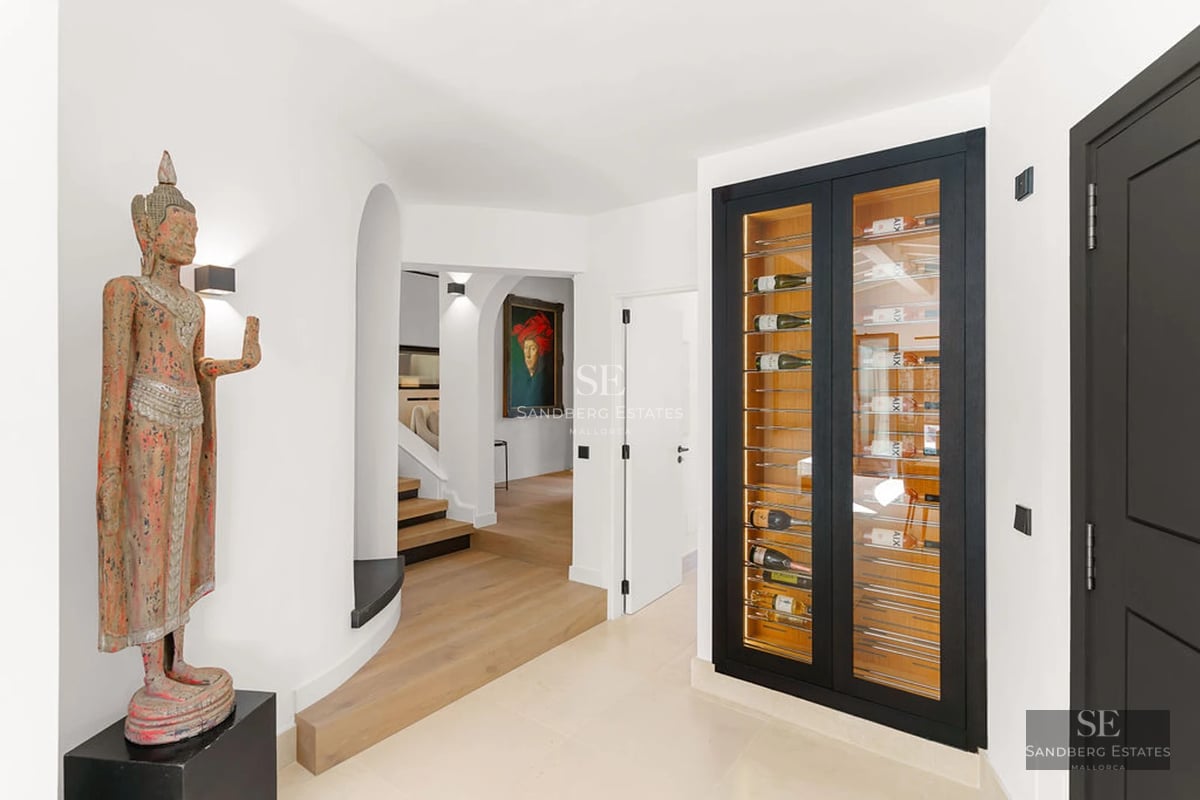 Modern penthouse featuring a spacious terrace, wooden flooring, glass railings, and panoramic sea views. Minimalist and elegant design.