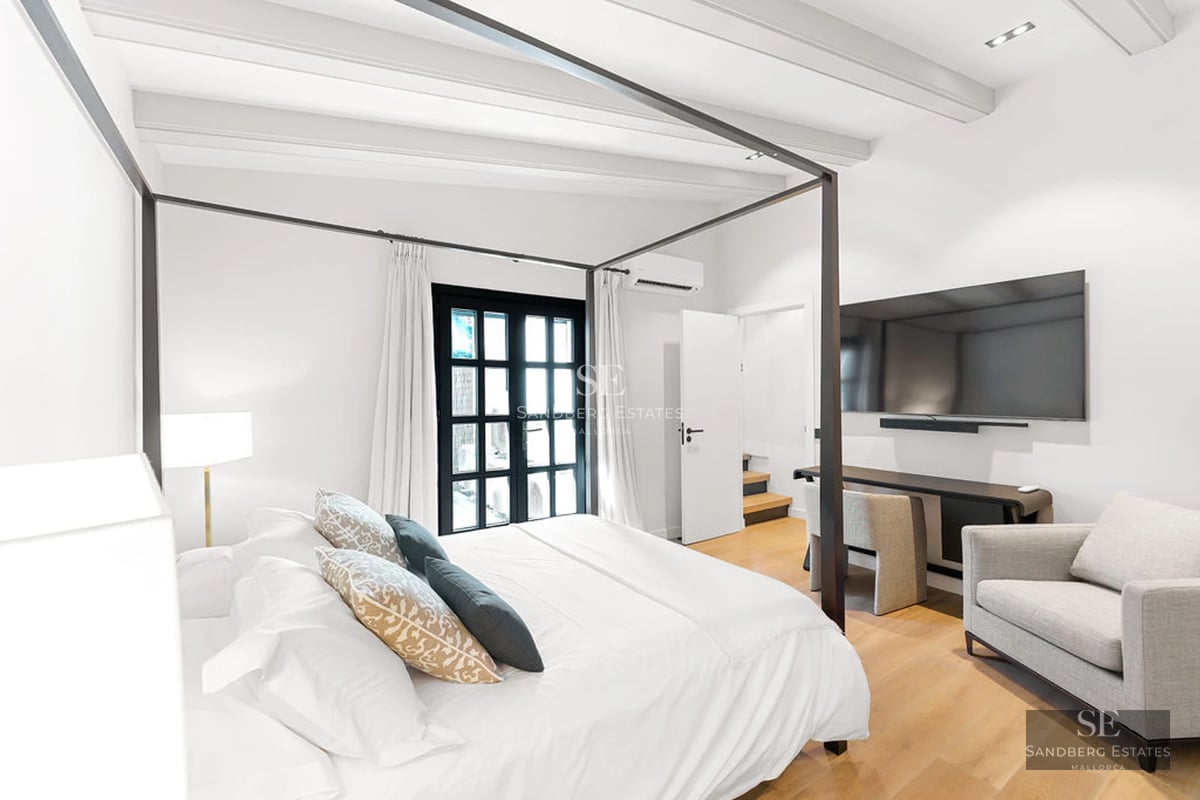 Spacious living room with picture windows, beige sofas, light wood coffee table, and modern decorative details. Natural lighting.