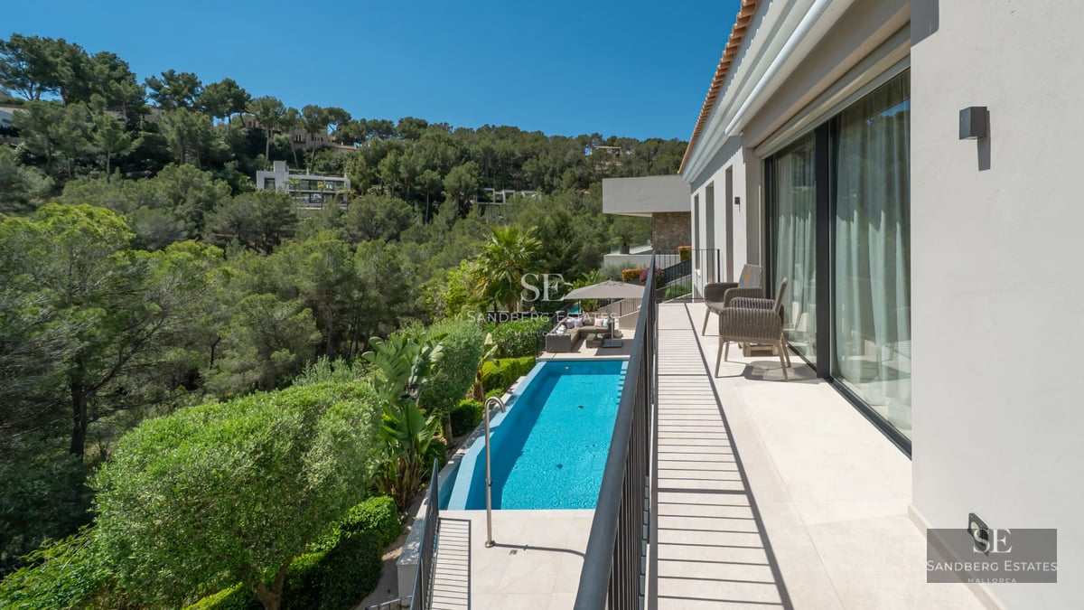 Exterior view of a modern villa featuring an infinity pool, expansive terraces, and lush garden. Minimalist architectural design and luxury finishes.